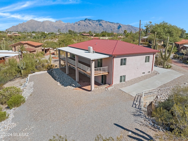 back of house featuring a mountain view and a balcony