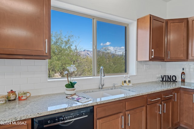 kitchen with light stone countertops, sink, backsplash, and black dishwasher