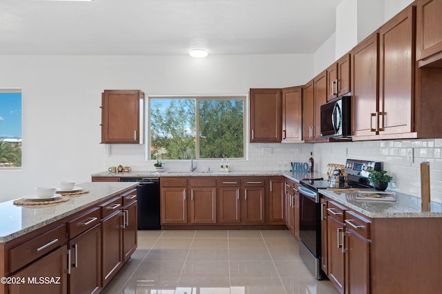 kitchen with black appliances, a wealth of natural light, sink, and light tile patterned floors