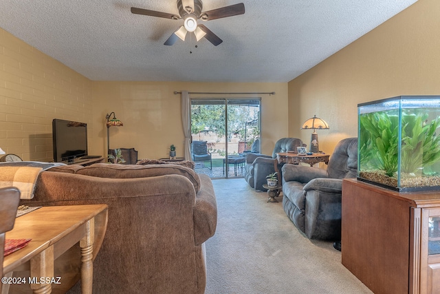 living room featuring brick wall, light carpet, a textured ceiling, and ceiling fan