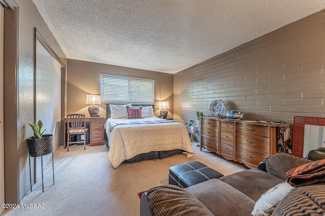 bedroom with light carpet, a textured ceiling, and brick wall