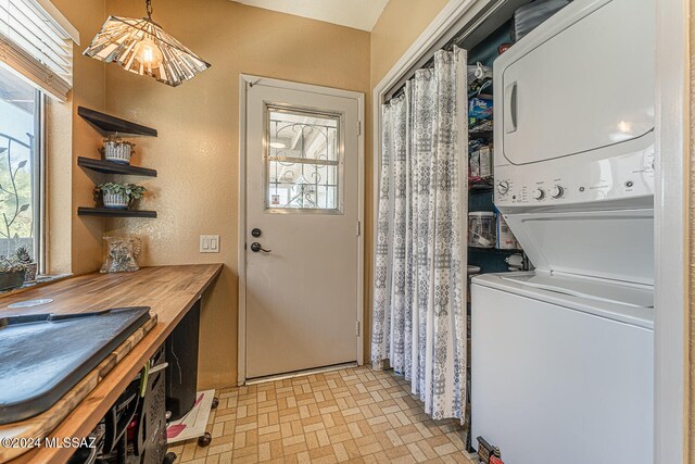 laundry room featuring stacked washer / drying machine