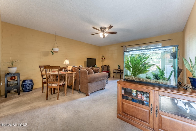 carpeted living room featuring ceiling fan, brick wall, and a textured ceiling