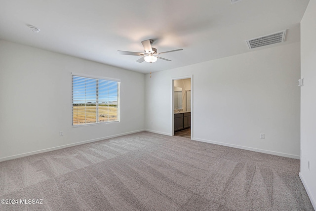 spare room featuring light colored carpet and ceiling fan