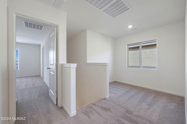 hallway featuring light colored carpet