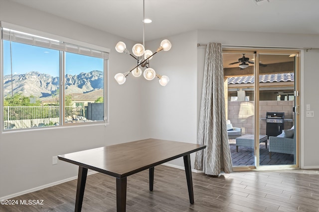 dining room with hardwood / wood-style flooring, a mountain view, and ceiling fan with notable chandelier