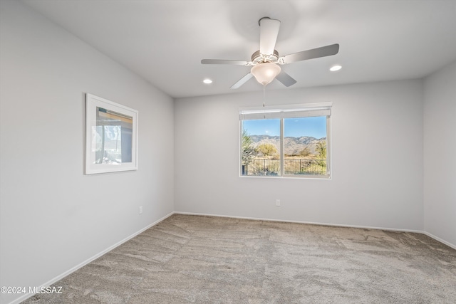 empty room featuring ceiling fan and light carpet