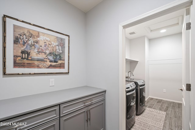 clothes washing area featuring separate washer and dryer and wood-type flooring