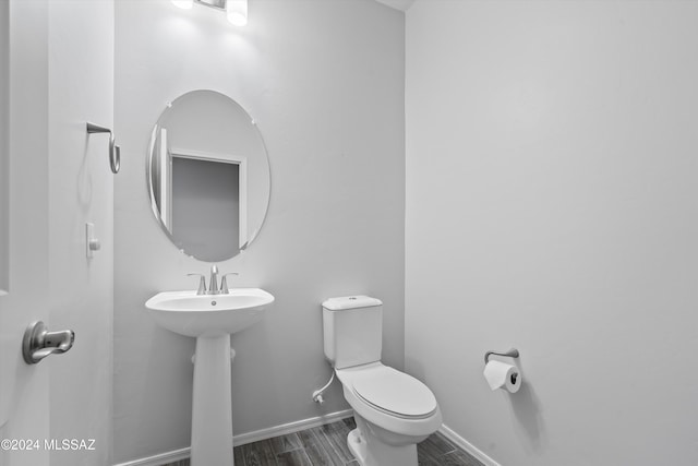 bathroom with hardwood / wood-style flooring, toilet, and sink