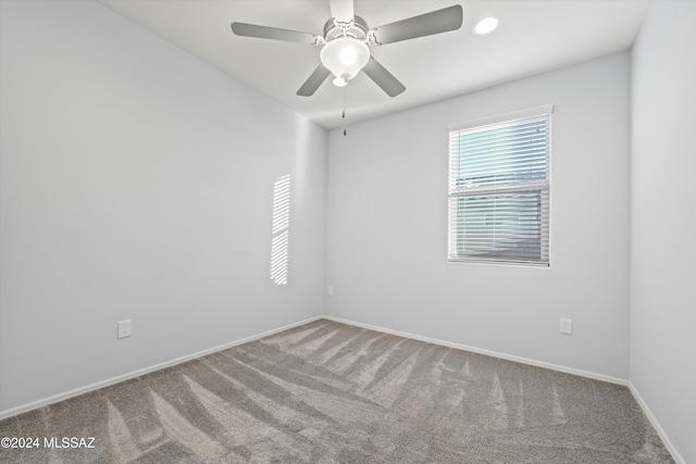 carpeted spare room with ceiling fan