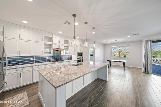 kitchen with a kitchen island with sink, appliances with stainless steel finishes, white cabinetry, and sink