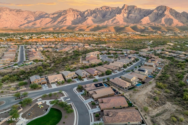 aerial view at dusk featuring a mountain view