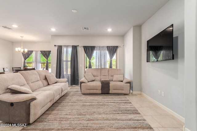 tiled living room featuring a healthy amount of sunlight and a chandelier