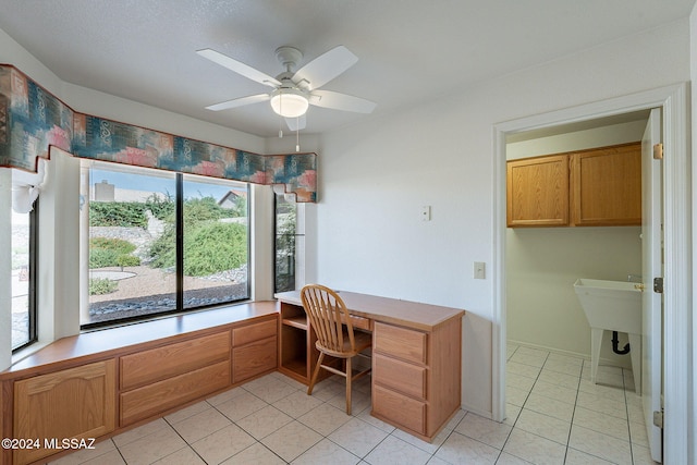 office area with built in desk, ceiling fan, a healthy amount of sunlight, and light tile patterned flooring