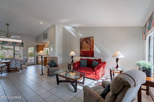 tiled living room with ceiling fan and vaulted ceiling