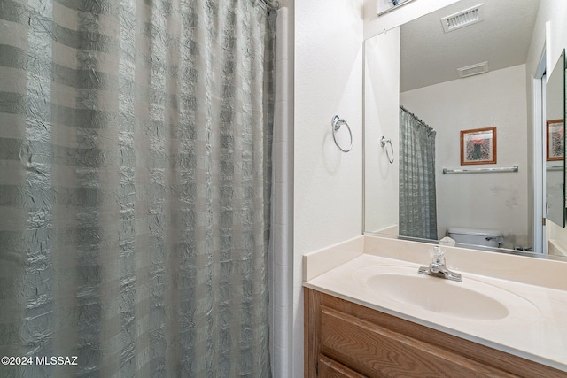 bathroom featuring toilet, a textured ceiling, vanity, and a shower with shower curtain