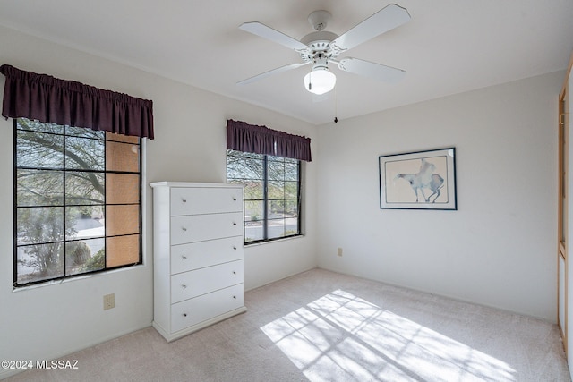 unfurnished bedroom featuring light carpet and ceiling fan