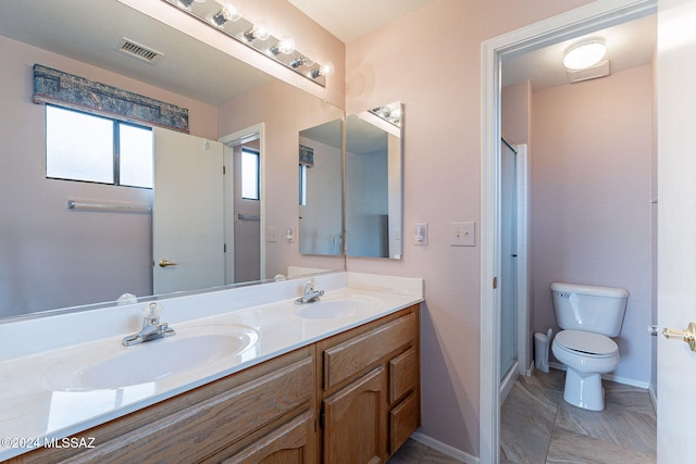 bathroom featuring vanity, toilet, and a shower with shower door