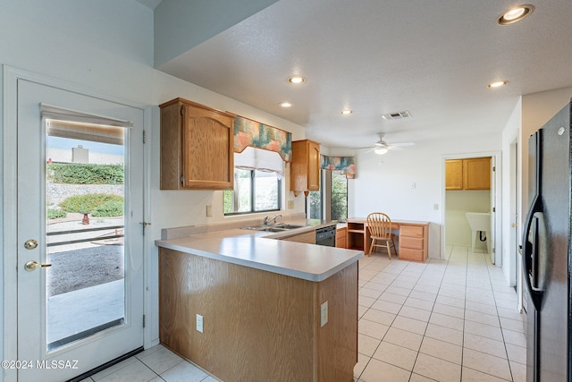 kitchen with kitchen peninsula, built in desk, ceiling fan, black appliances, and sink