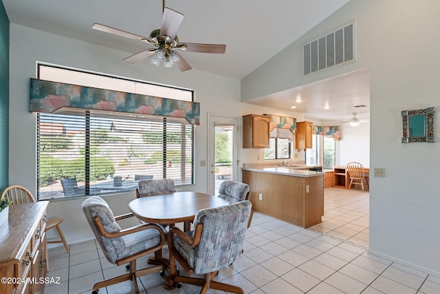 dining area with light tile patterned floors, lofted ceiling, and ceiling fan