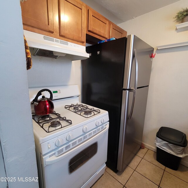 2112 E 18th St, Tucson, AZ 85719 - kitchen featuring stainless steel fridge, light tile patterned floors, and white gas range