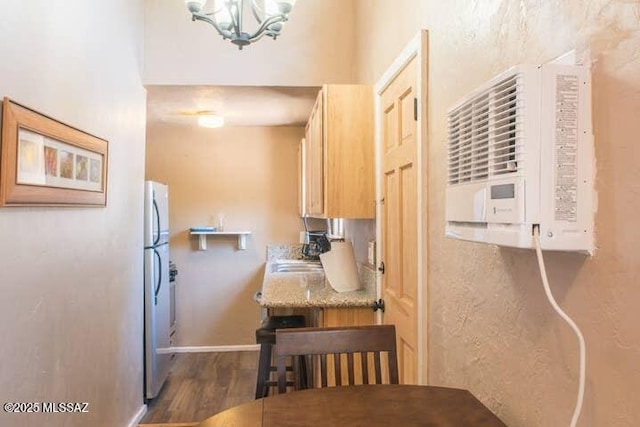 2112 E 18th St, Tucson, AZ 85719 - kitchen featuring an AC wall unit, sink, dark hardwood / wood-style floors, stainless steel fridge, and a chandelier
