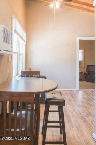 2112 E 18th St, Tucson, AZ 85719 - dining space featuring an AC wall unit, beamed ceiling, wood-type flooring, and a high ceiling