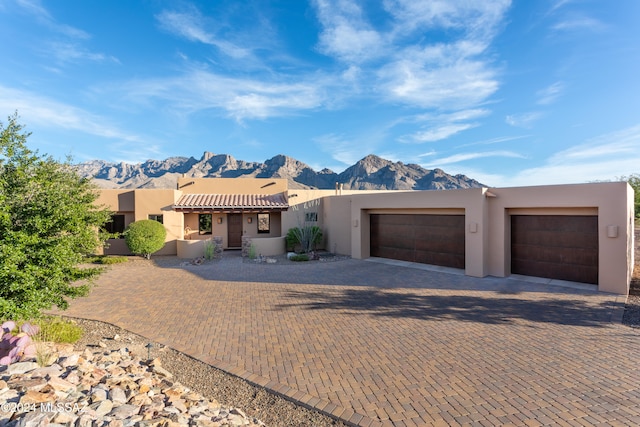 pueblo revival-style home with a mountain view and a garage