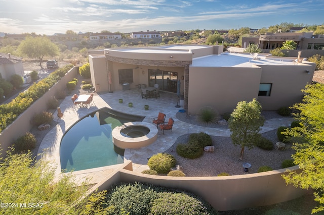 back of house with a swimming pool with hot tub and a patio area