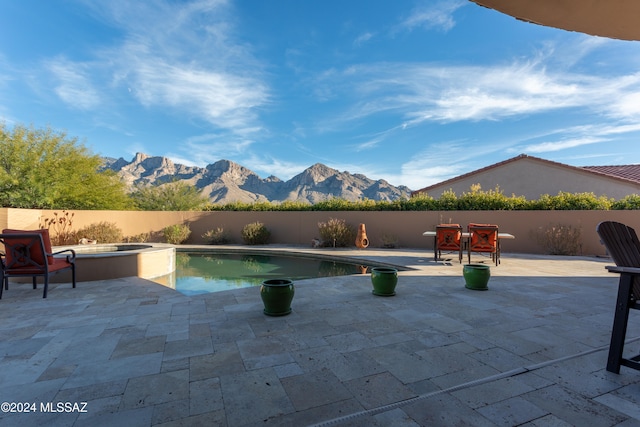 view of swimming pool with a mountain view, an in ground hot tub, and a patio area