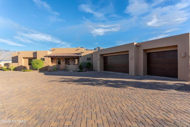 pueblo revival-style home featuring a garage