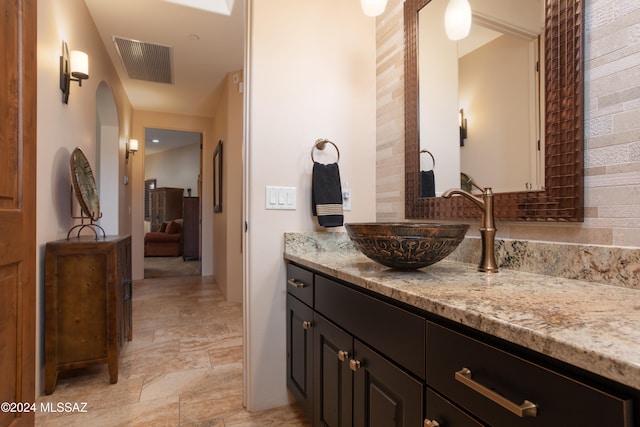 bathroom with tasteful backsplash and vanity