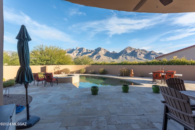 view of pool featuring a mountain view, a patio, an in ground hot tub, and ceiling fan