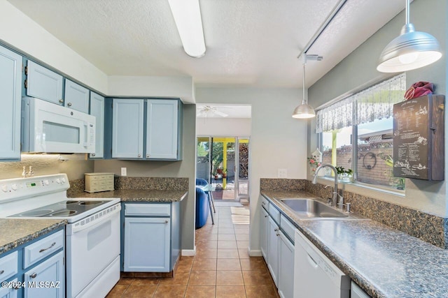 kitchen with light tile patterned flooring, a textured ceiling, pendant lighting, sink, and white appliances