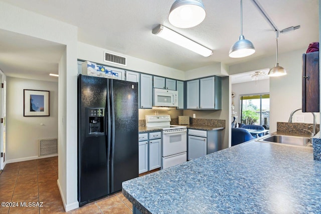 kitchen featuring pendant lighting, white appliances, sink, and light tile patterned flooring