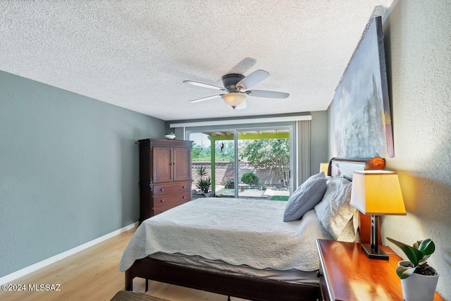 bedroom featuring ceiling fan, a textured ceiling, light hardwood / wood-style floors, and access to exterior