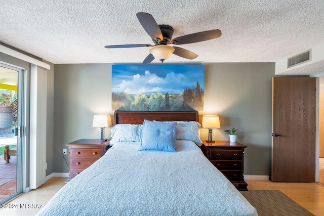 bedroom with light hardwood / wood-style flooring, a textured ceiling, ceiling fan, and access to exterior