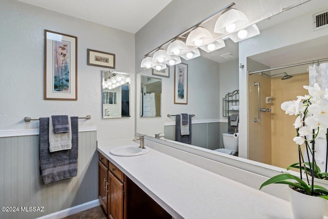 bathroom with walk in shower, vanity, and toilet