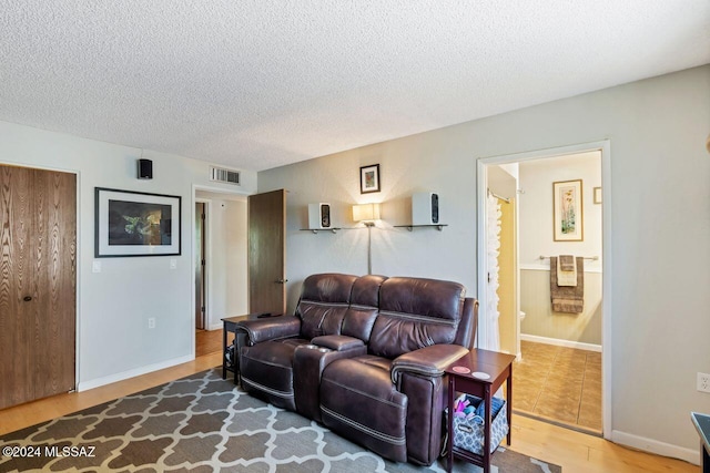 living room with wood-type flooring and a textured ceiling