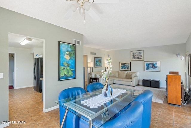 dining space featuring tile patterned flooring, a textured ceiling, and ceiling fan