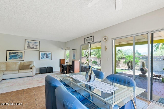 tiled dining room featuring ceiling fan and a textured ceiling