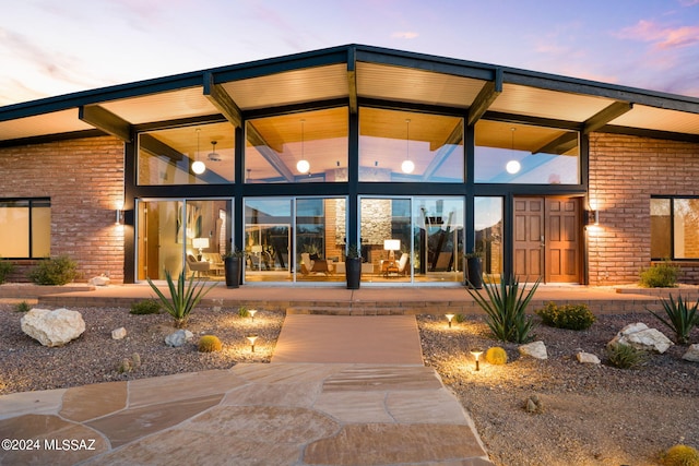 exterior entry at dusk featuring a patio