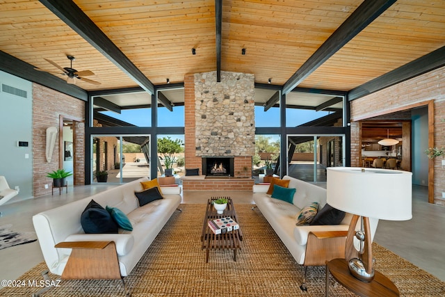 living room with concrete flooring, expansive windows, a stone fireplace, and a wealth of natural light