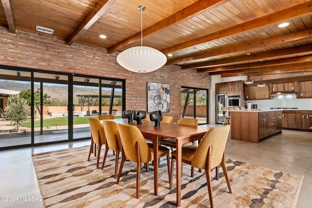 dining room with beam ceiling, wooden ceiling, and brick wall