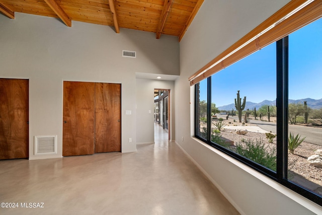 hall with beamed ceiling, a mountain view, wood ceiling, and high vaulted ceiling