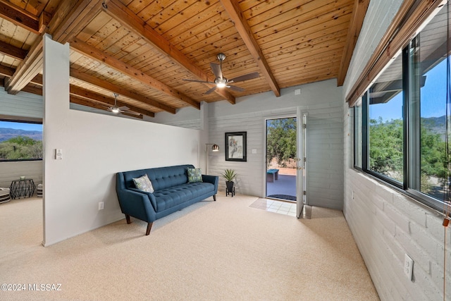 sitting room featuring carpet flooring, ceiling fan, wooden ceiling, beamed ceiling, and brick wall