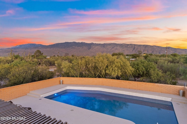 view of pool with a fenced backyard, a mountain view, and a fenced in pool