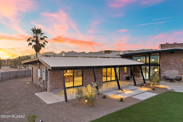 back house at dusk with a patio