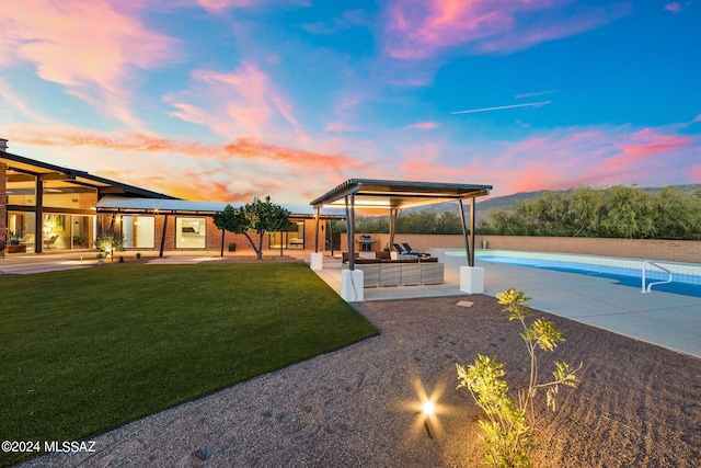 yard at dusk featuring a patio