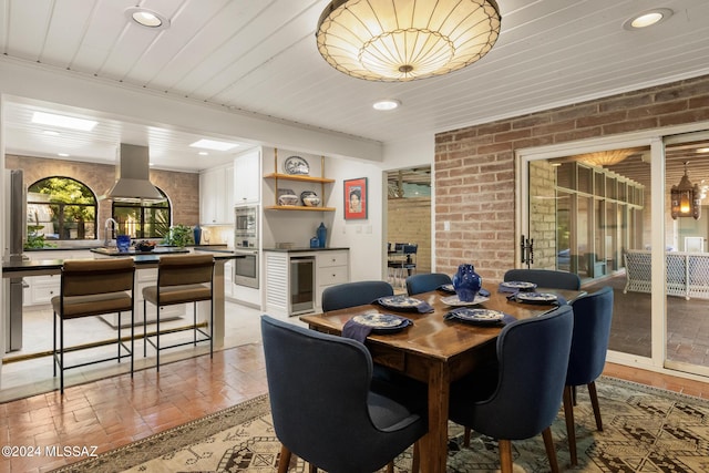 dining room with wine cooler and brick wall